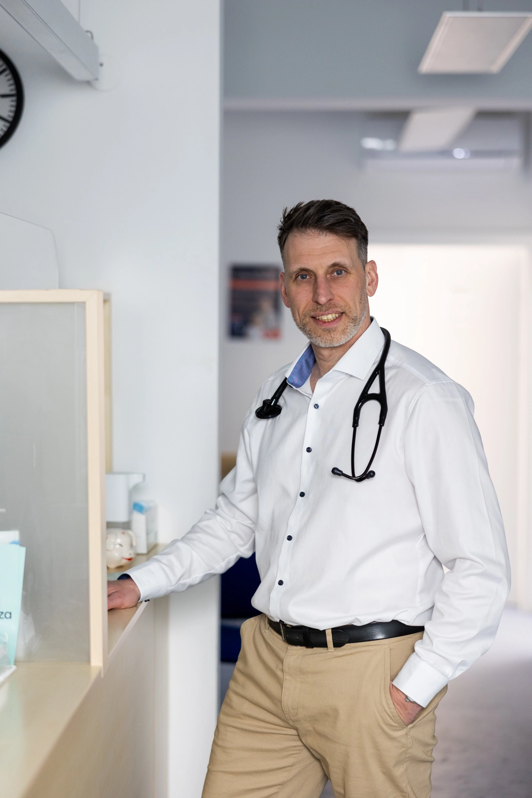 Dr. Arne Ebermann stehend in seiner Ordination, Porträtaufnahme